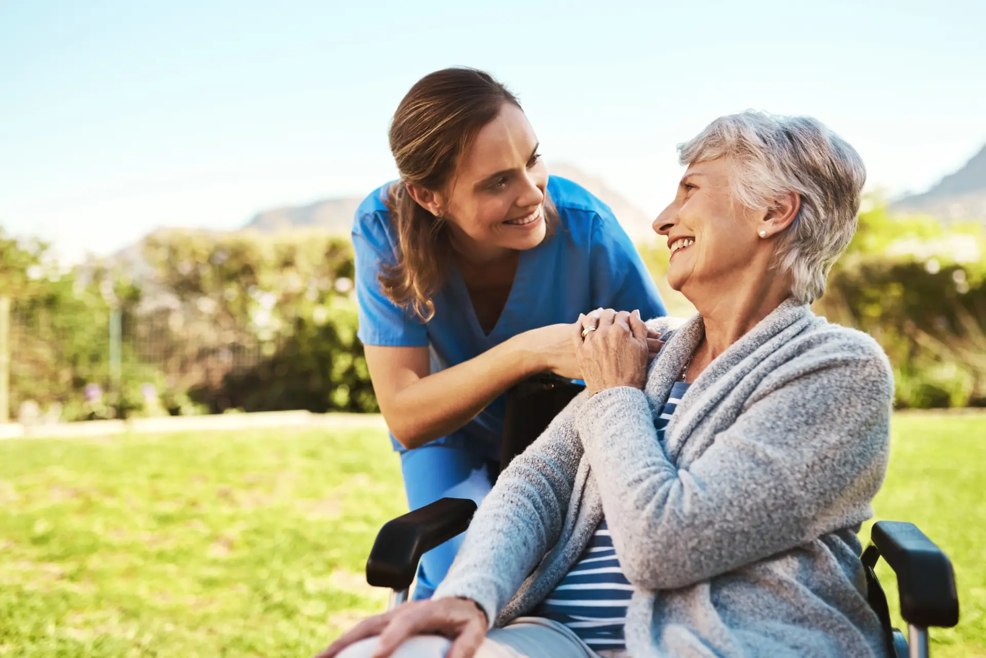 Senior woman, nurse and wheelchair in life insurance, healthcare support or garden at nursing home. Happy elderly female and caregiver for person with a disability, health or retirement in nature